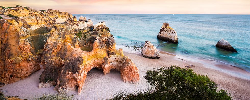 Colorful rock formations on Portugal's Prais Dos Tres Irmaos Beach