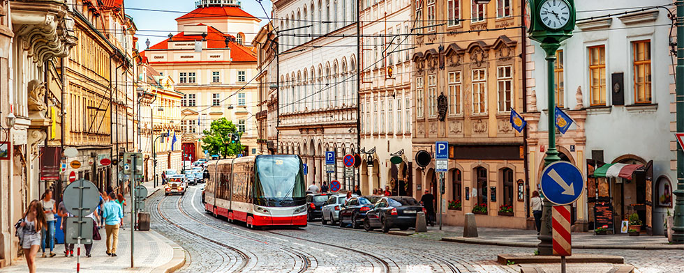 Cobblestoned Prague street with pedestrians and tram