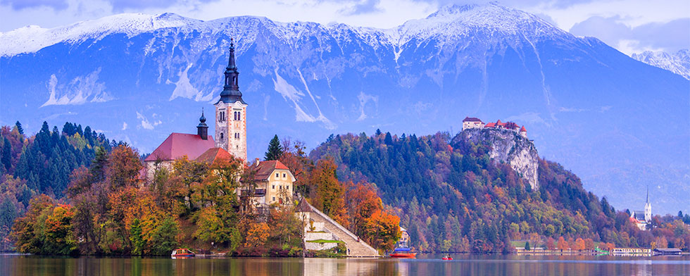 Church on an island in Lake Bled, Slovenia with mountains behind
